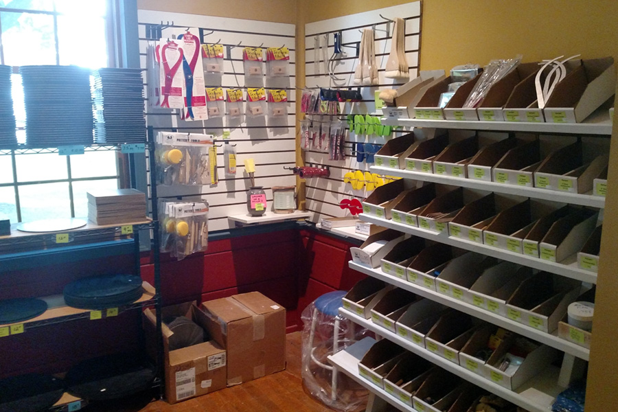 A shop sales room with pottery supplies on shelves and hanging on the walls.